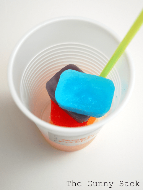 Kool Aid ice cubes stacked in a plastic cup
