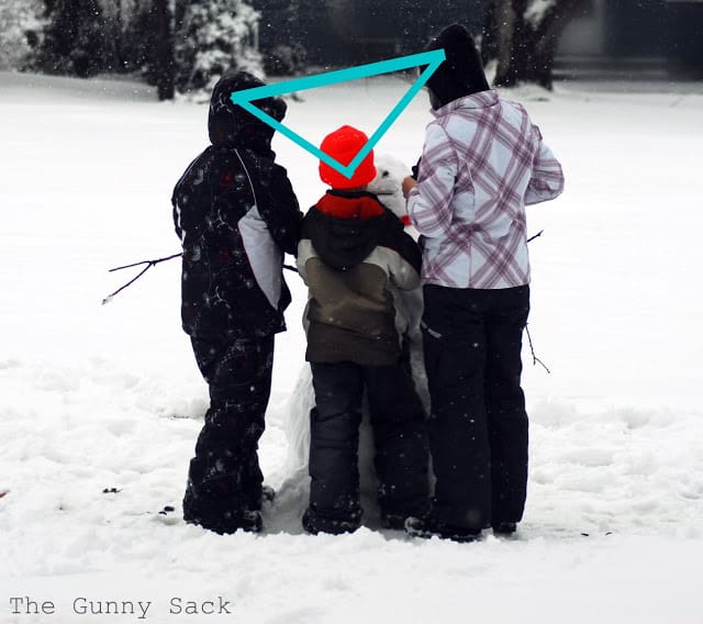 Three Kids Building A Snowman Shape in Photography