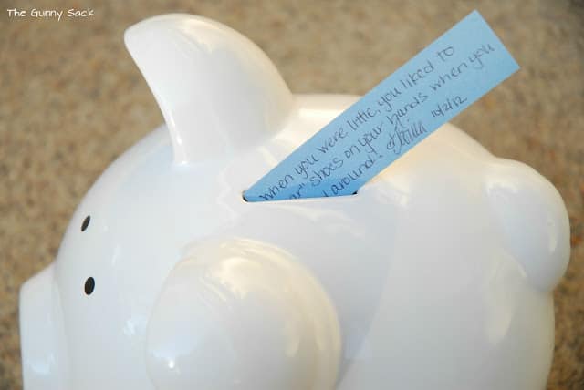 paper being inserted into piggy bank