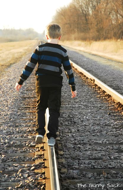boy on railroad tracks
