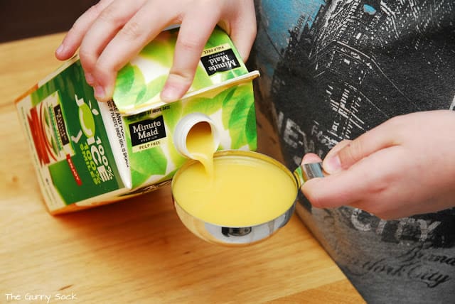 pour orange juice into cup