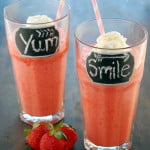 strawberry smoothies in glasses with whipped cream and straws
