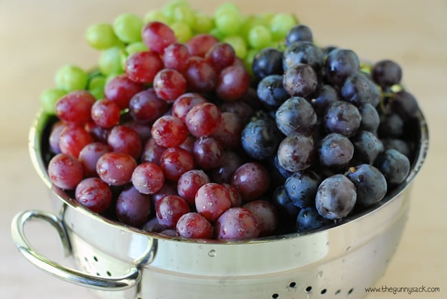Green, red, and black grapes in colander