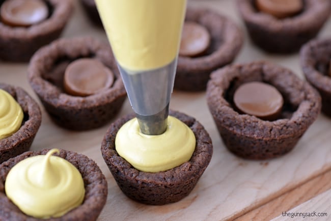 Pipe Golden Frosting Into Cookie Cups