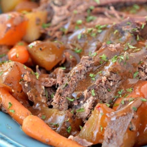 pot roast, carrots and potatoes on a blue platter