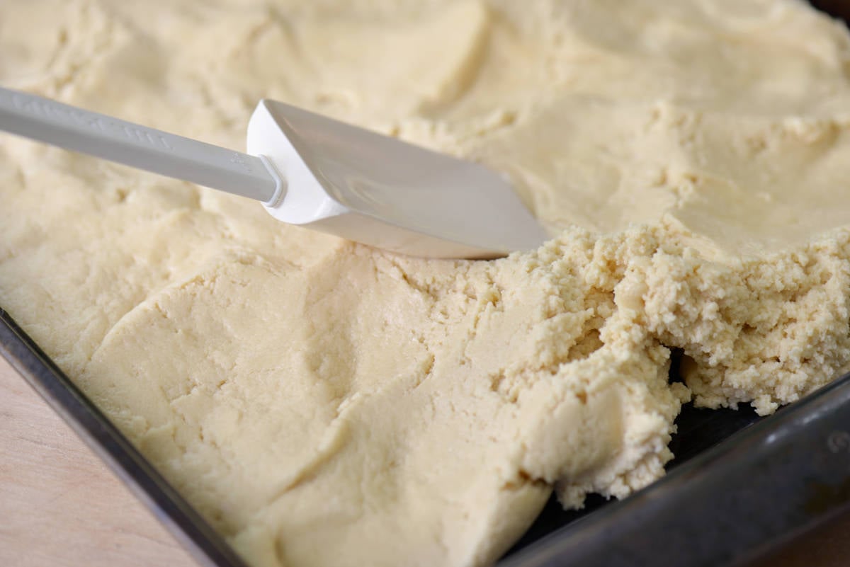 Sugar cookie bars dough in a sheet pan.