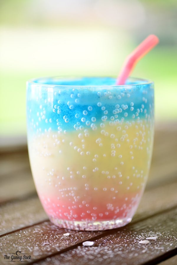 pink yellow and blue layered drink in cup