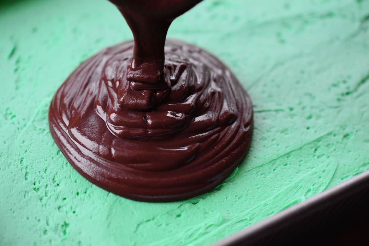 Pour chocolate mint ganache over the frosting.