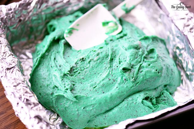 chocolate mint Oreo fudge being spread in a pan with a spatula