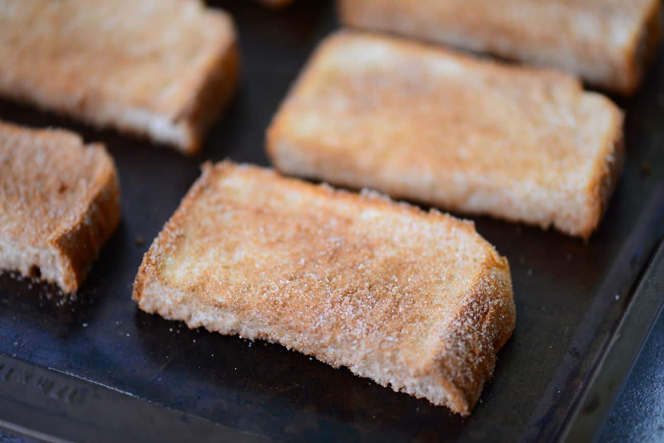 sugared slices of bread lined up on a pan