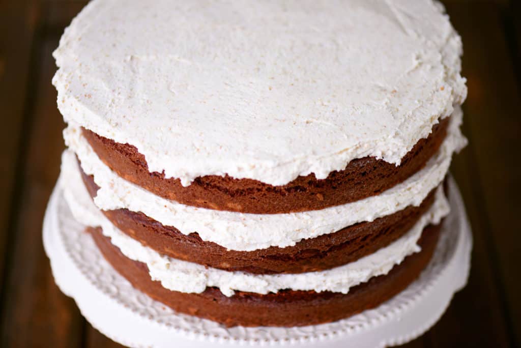 three chocolate cakes stacked with buttercream frosting between each layer