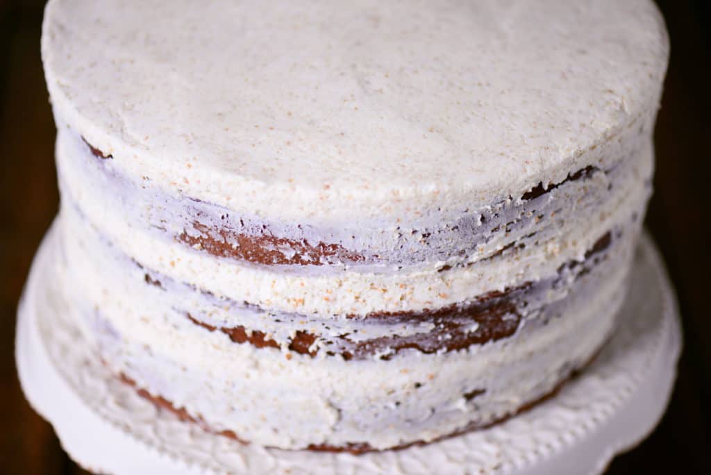three cakes stacked and lightly frosted with white buttercream frosting