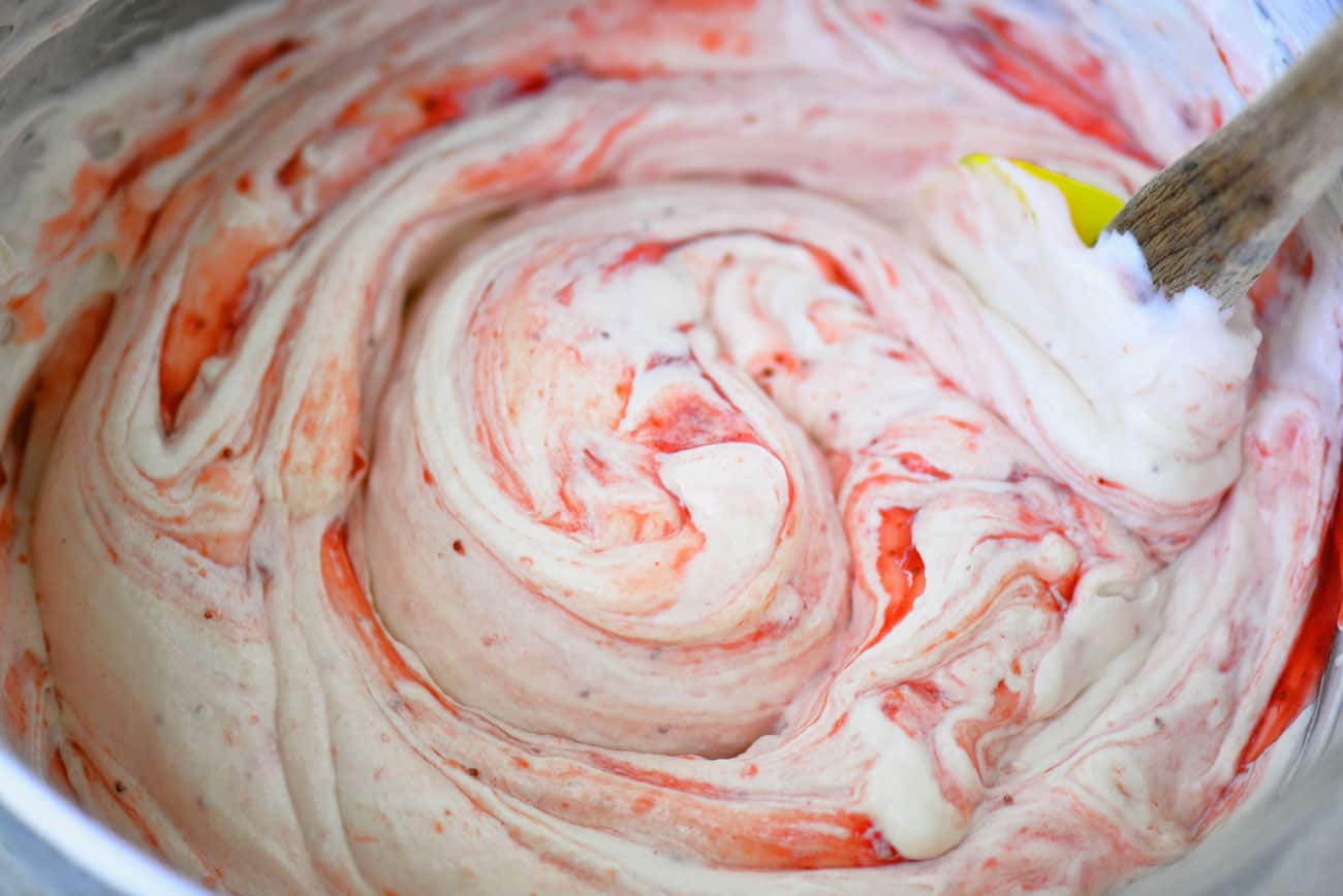 strawberry puree being blended with cream cheese mixture
