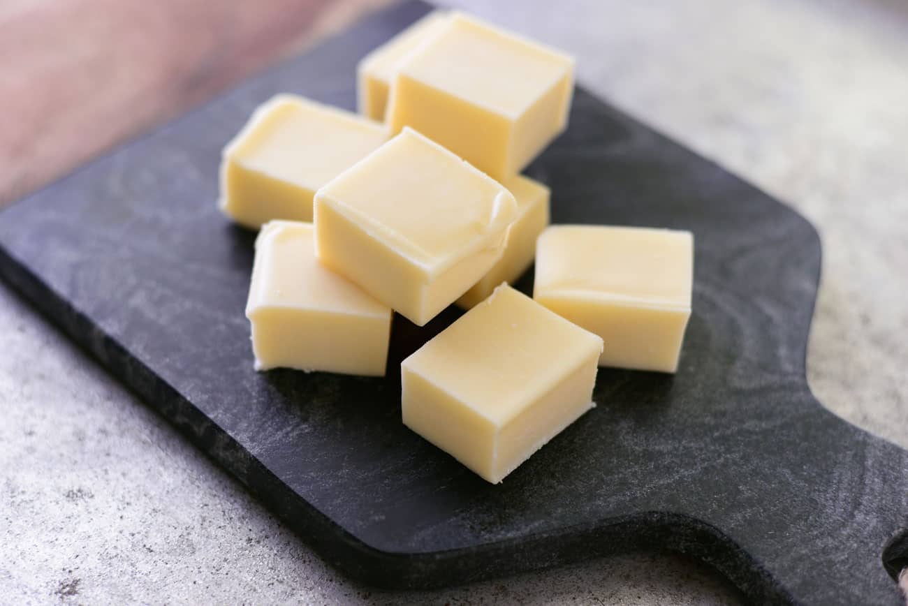 cubes of mozzarella cheese on a black cutting board