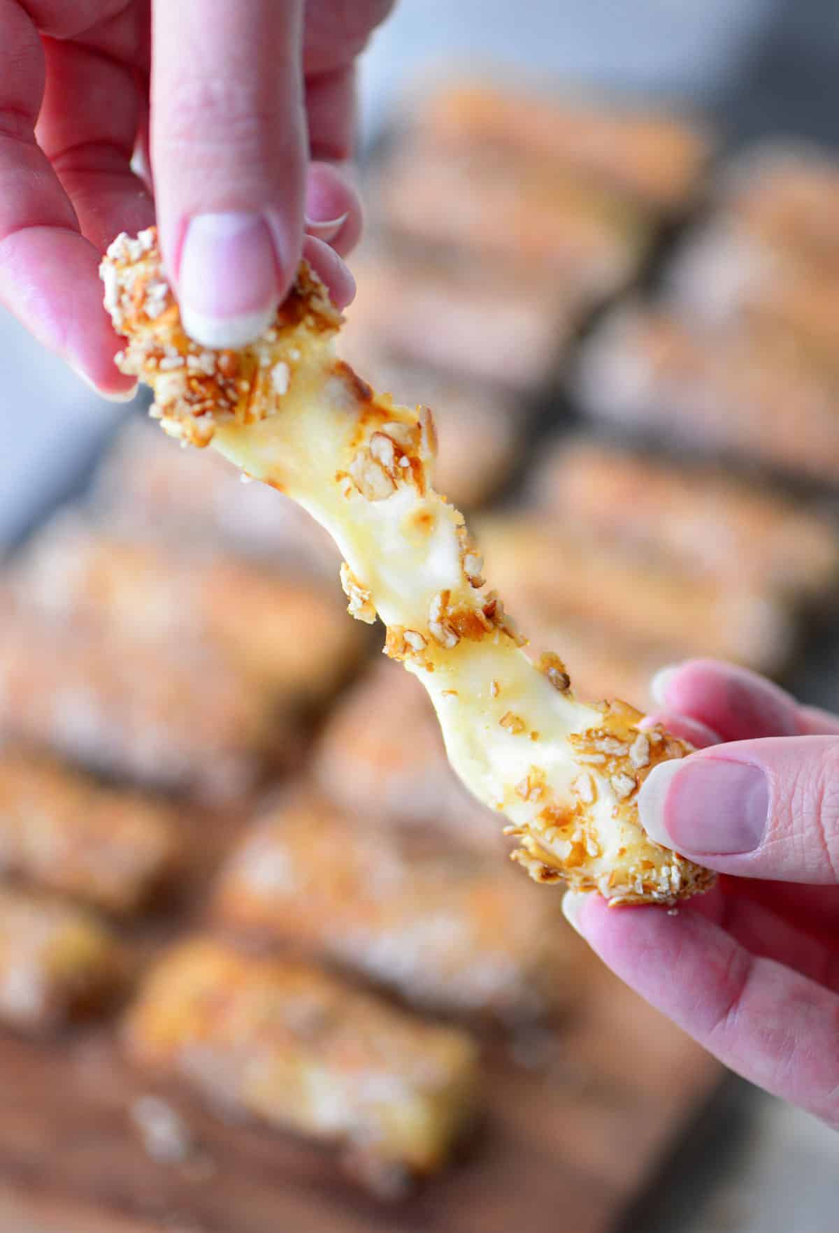 pretzel crusted mozzarella cheese sticks being pulled apart