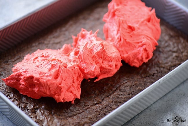 red frosting piled on top of the brownies 