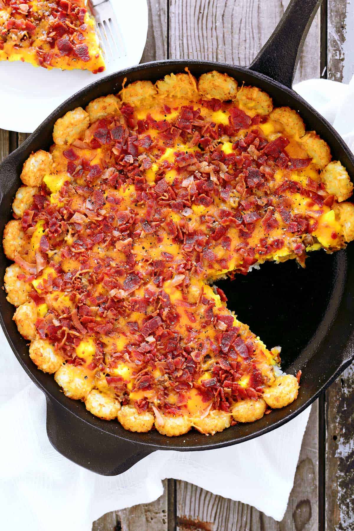 Tater tot breakfast casserole with a slice removed.