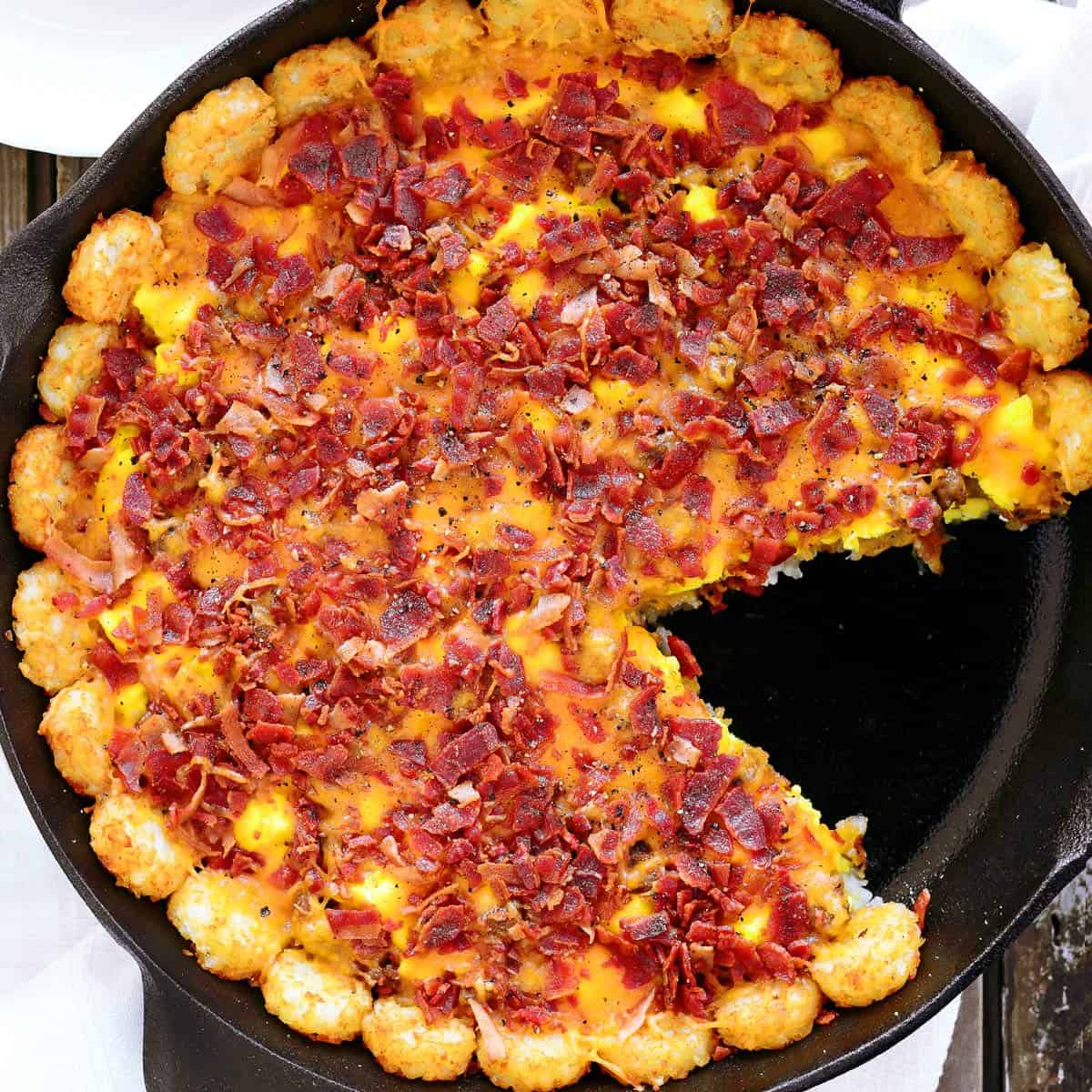Tater tot breakfast casserole with a slice removed.