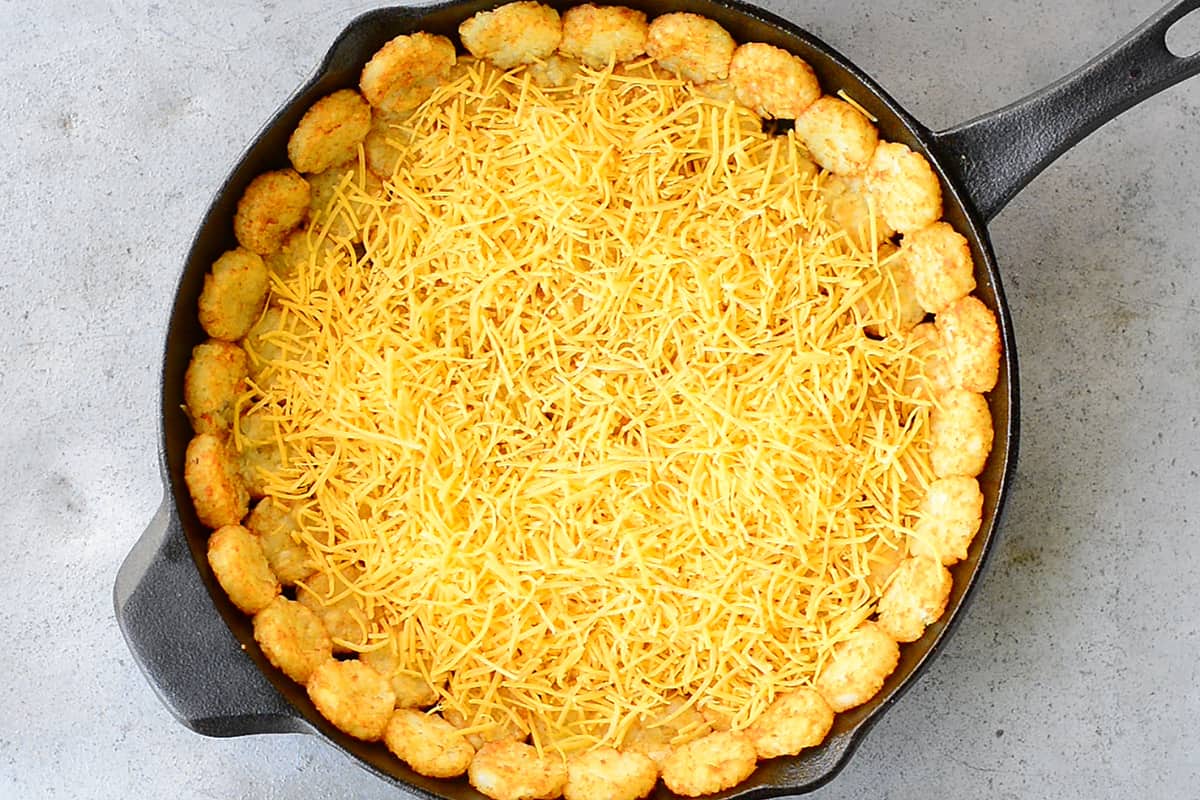 Shredded Cheddar Cheese On Top Of Tater Tots