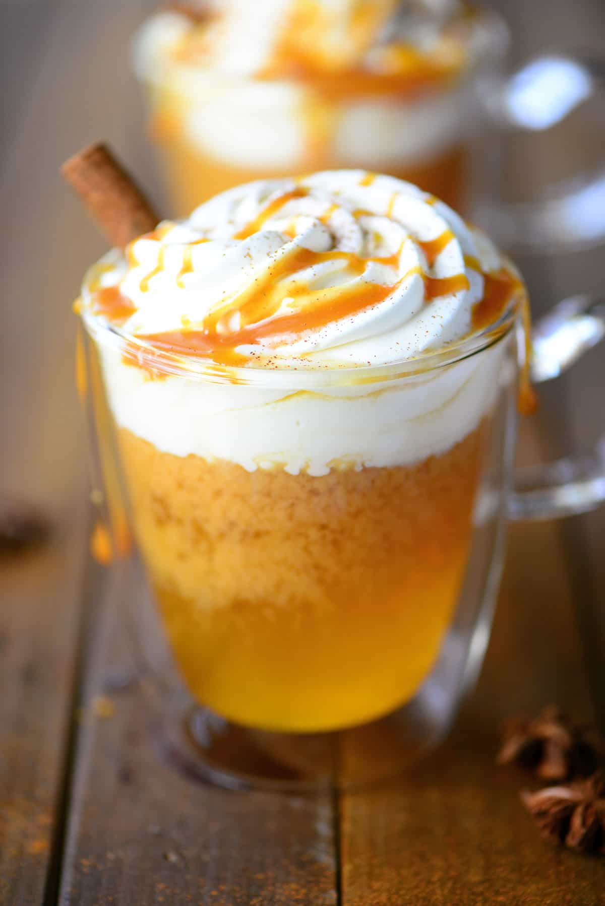 Slow Cooker Apple Cider in a Glass Mug with Caramel and Whipped Cream On Top