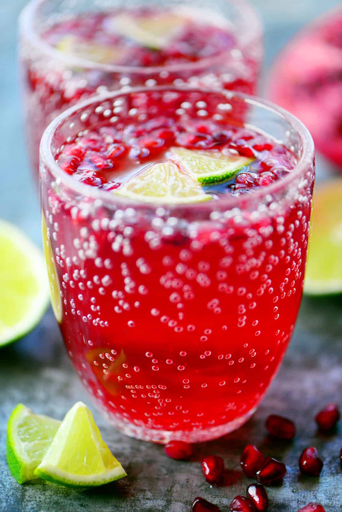 Pomegranate Lime Holiday Punch in cup with lime wedges