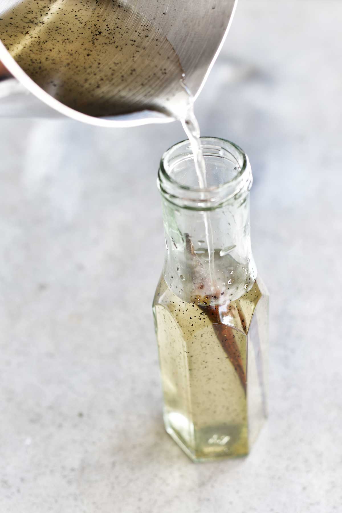 homemade vanilla be syrup being poured into a glass bottle