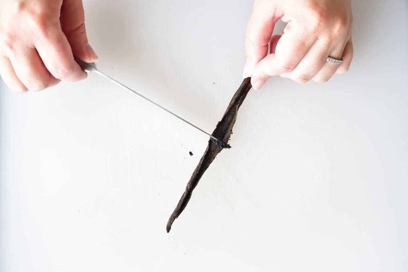 scraping seeds from vanilla bean with knife