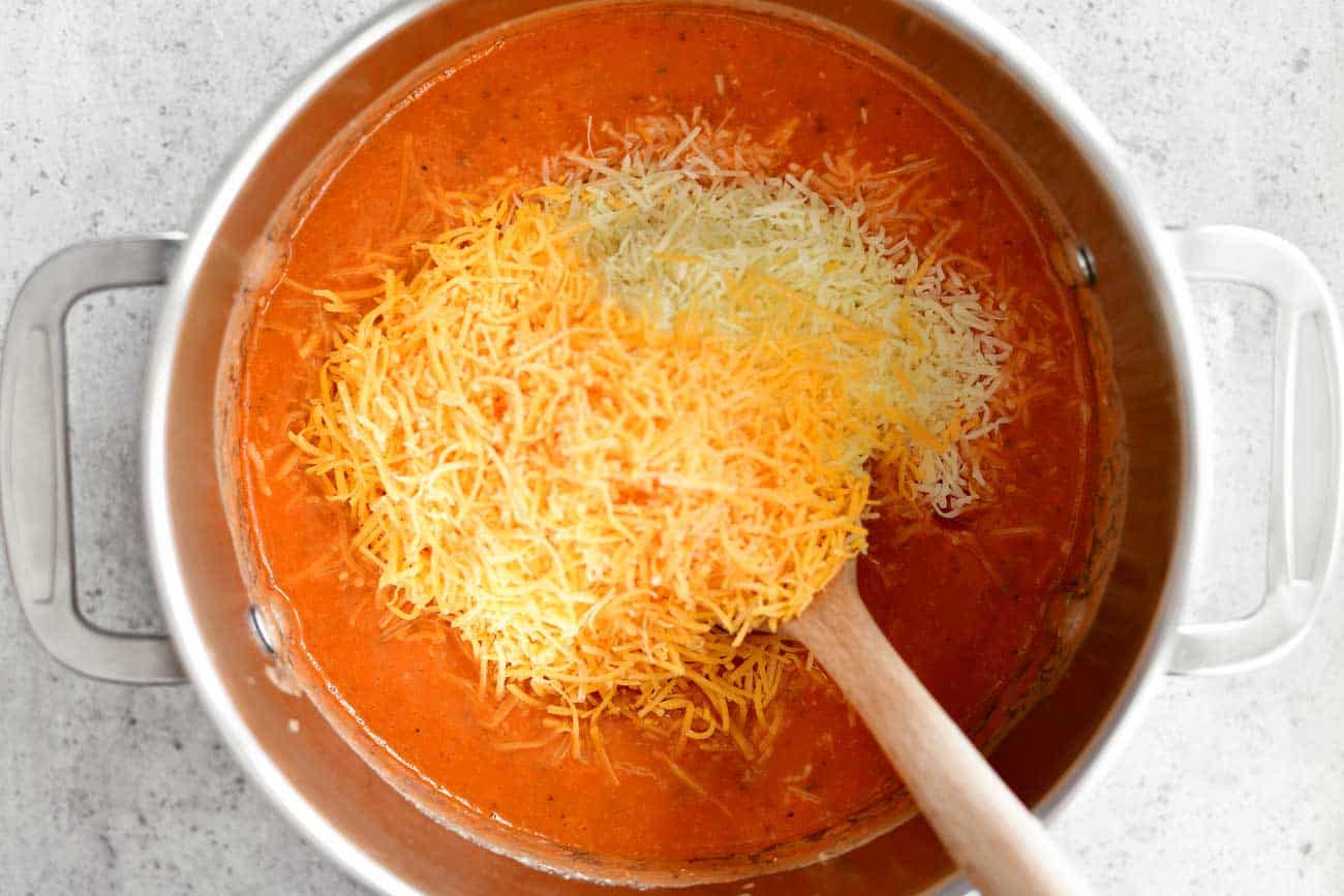 shredded cheese on pizza soup in pot