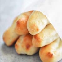 stack of two ingredient dough breadsticks wrapped in parchment paper