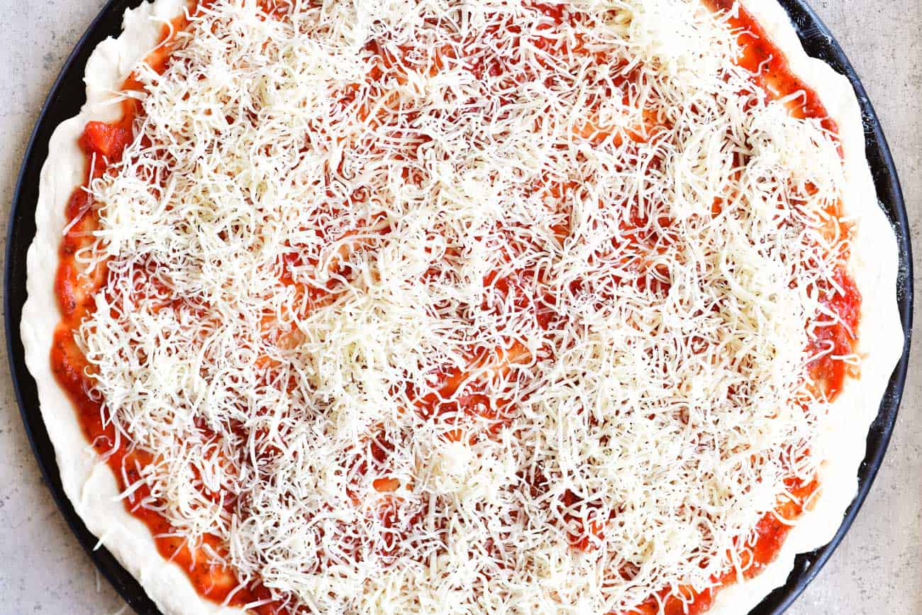 sprinkle cheese on two ingredient dough pizza crust