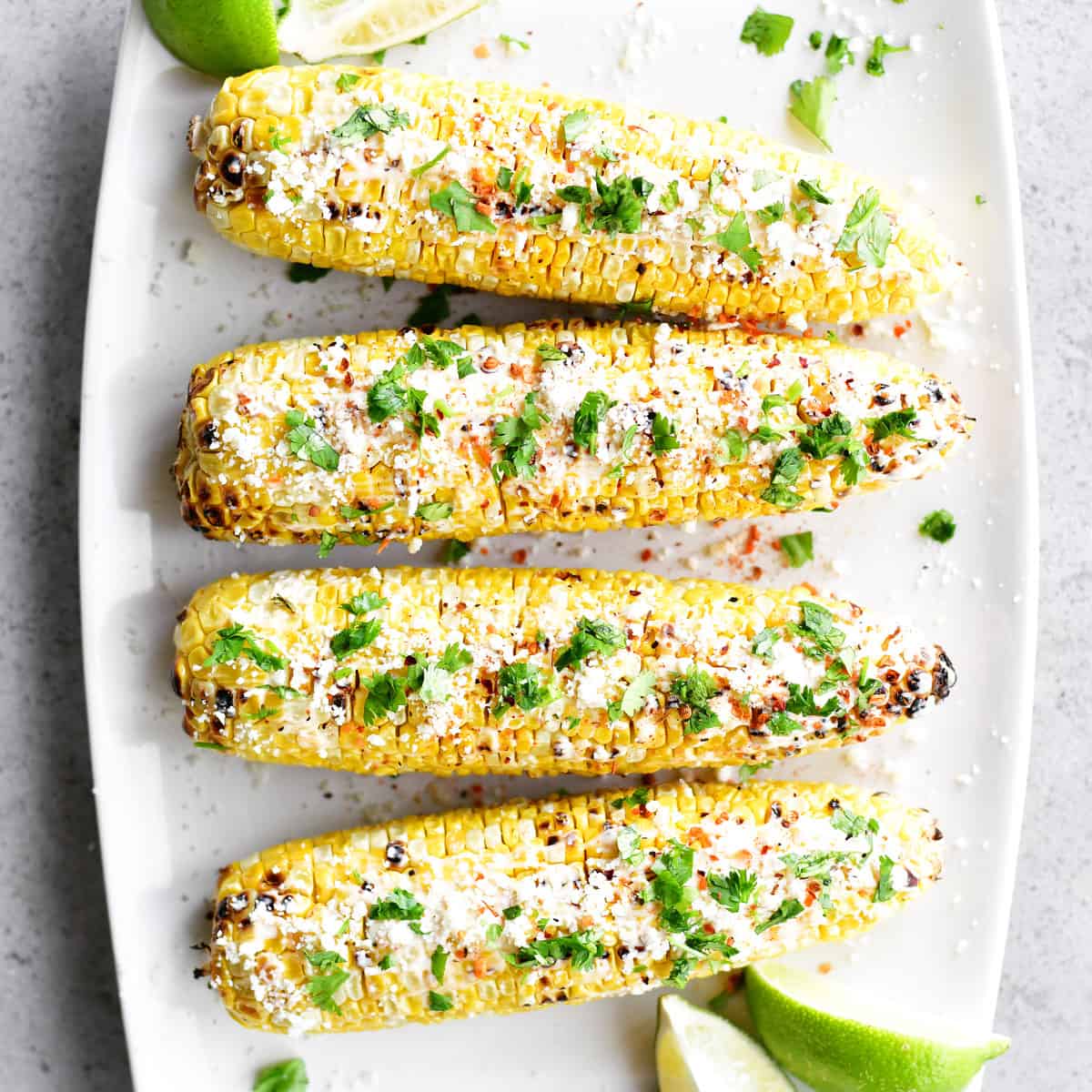 Mexican street corn on a white platter.