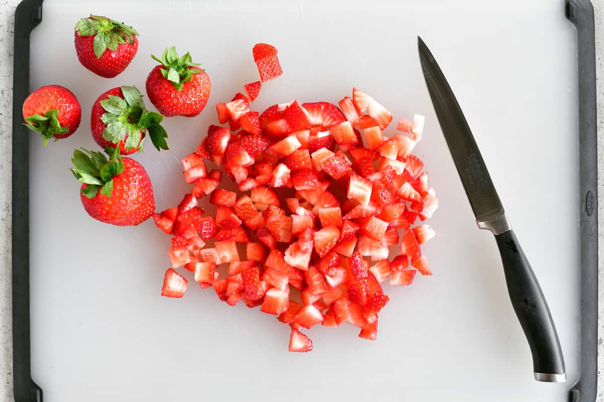 diced strawberries on cutting board for strawberry jello salad