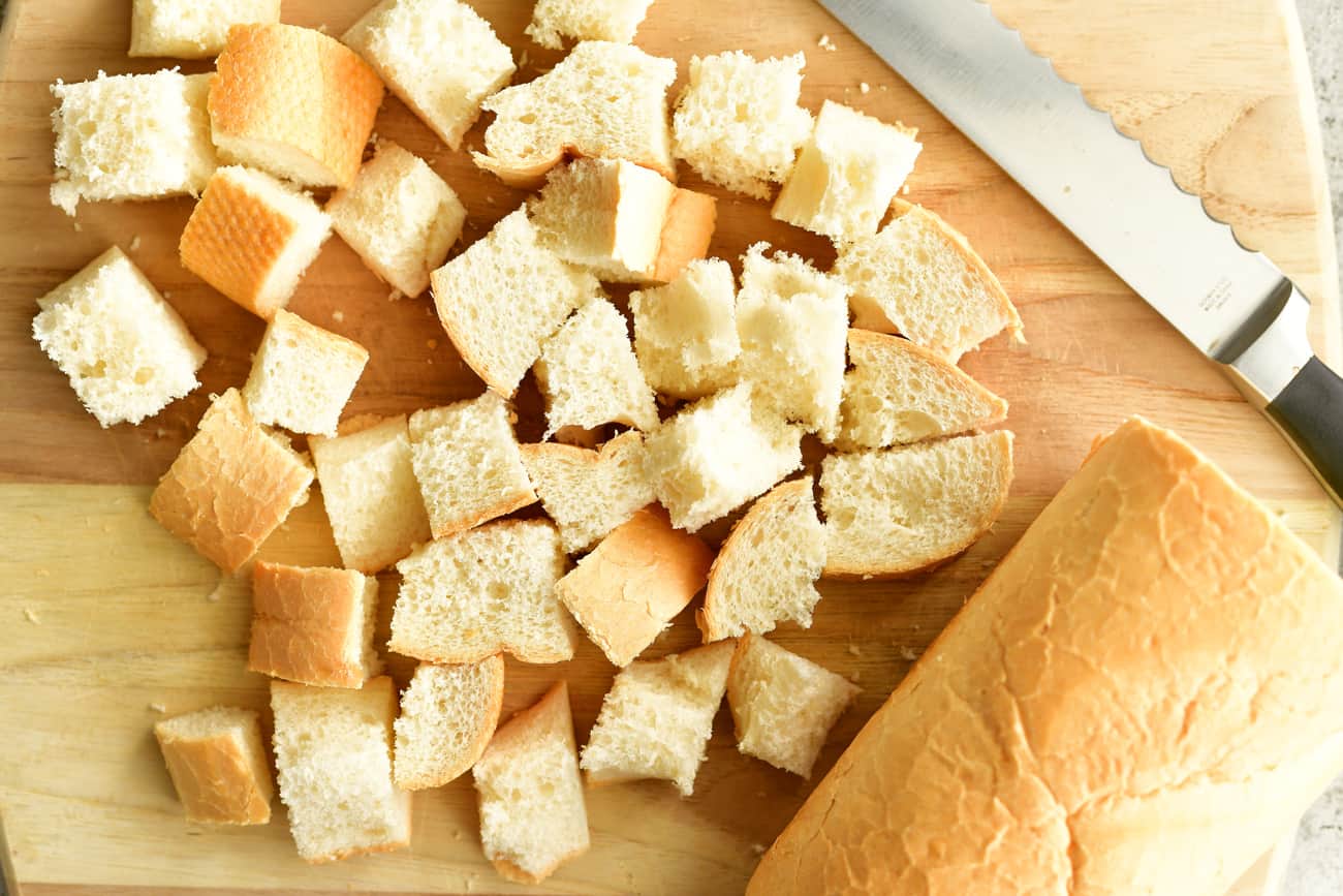 cutting bread into cubes for dipping in smoked gouda fondue