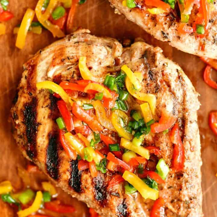 grilled Jamaican jerk chicken breast with sliced peppers and onions on top