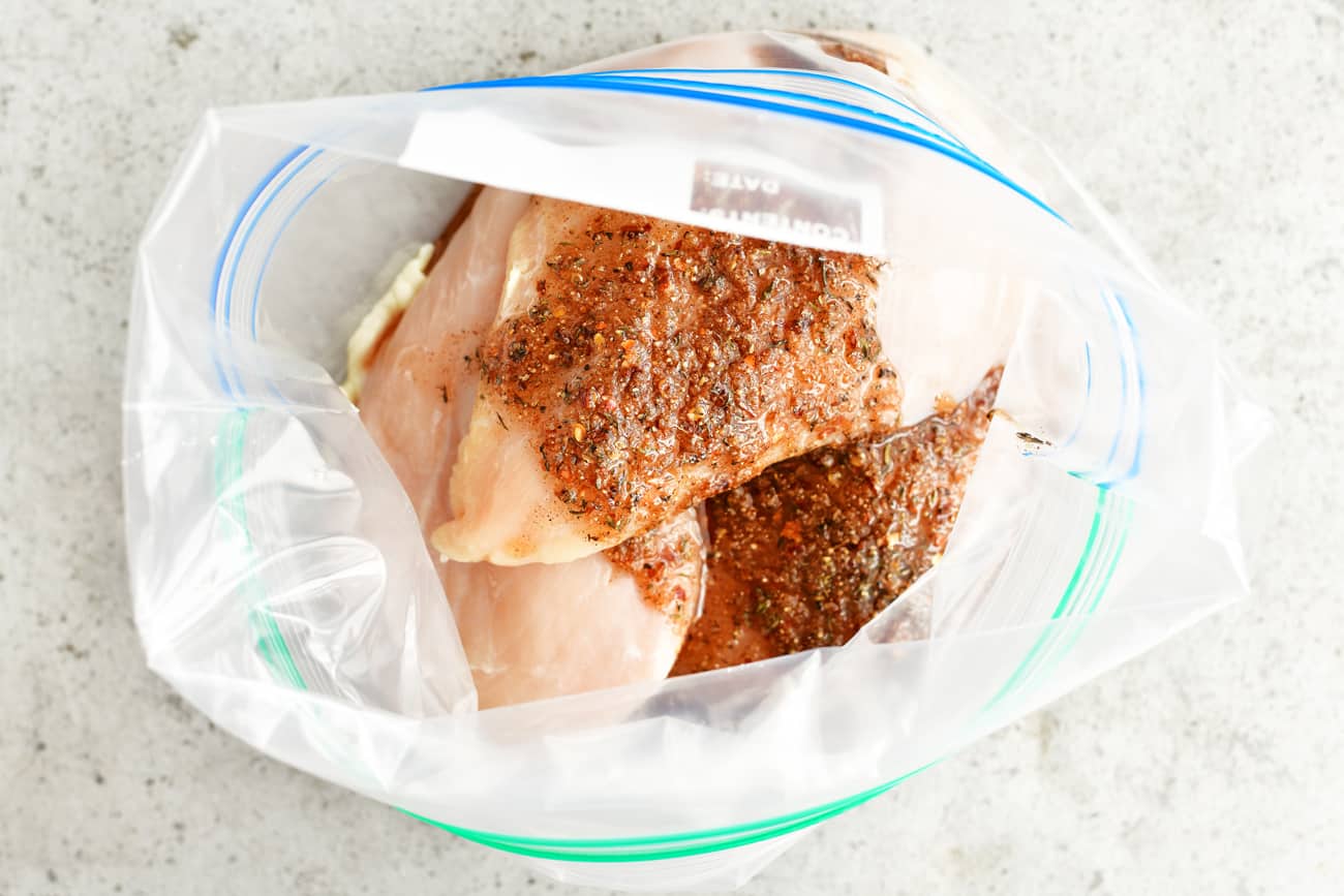 Jamaican jerk marinade on raw chicken breasts in plastic bag