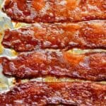 Crispy oven baked bacon strips in rows.
