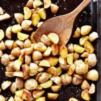 oven roasted potatoes in sheet pan with wooden spoon