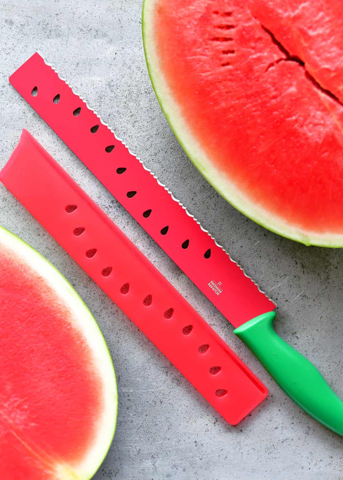 A watermelon knife with two watermelon halves.