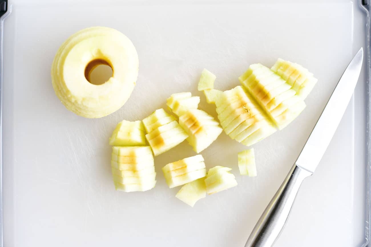 sliced apples on a cutting board with a knife