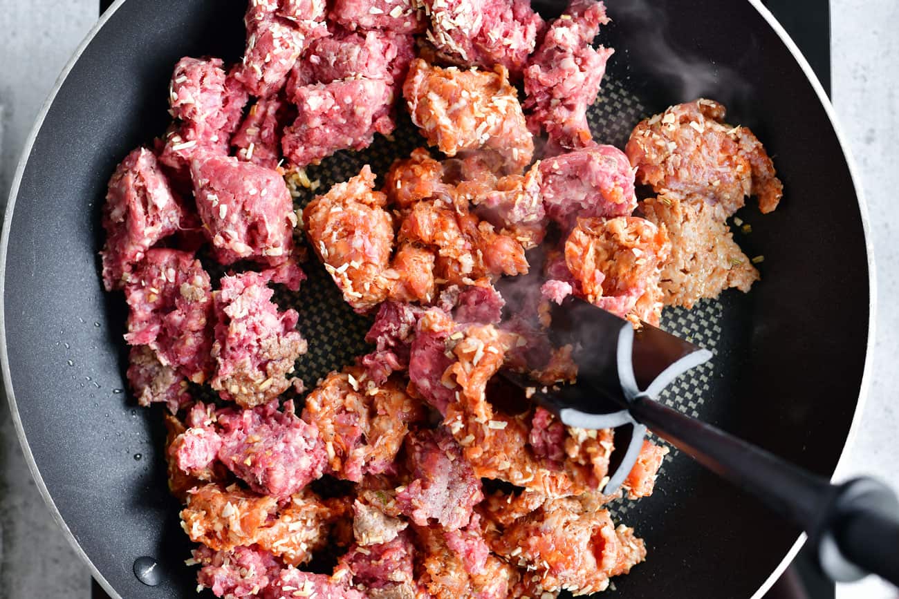 browning ground beef and Italian sausage in a frying pan
