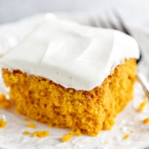 A slice of pumpkin cake on a white plate.