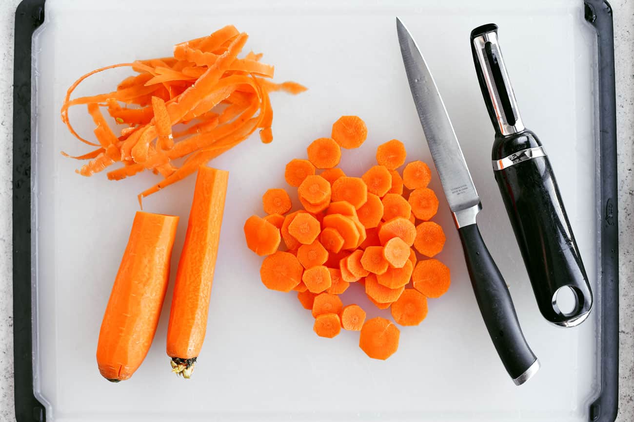 peeled and sliced carrots on a white cutting board