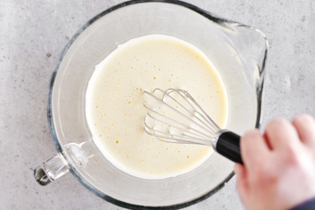 whipped eggs in a bowl with a whisk
