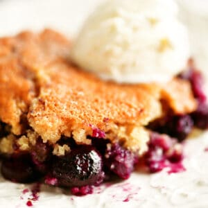 a slice of blueberry cobbler with ice cream on top.