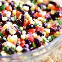 black beans and corn salsa in bowl surrounded by chips