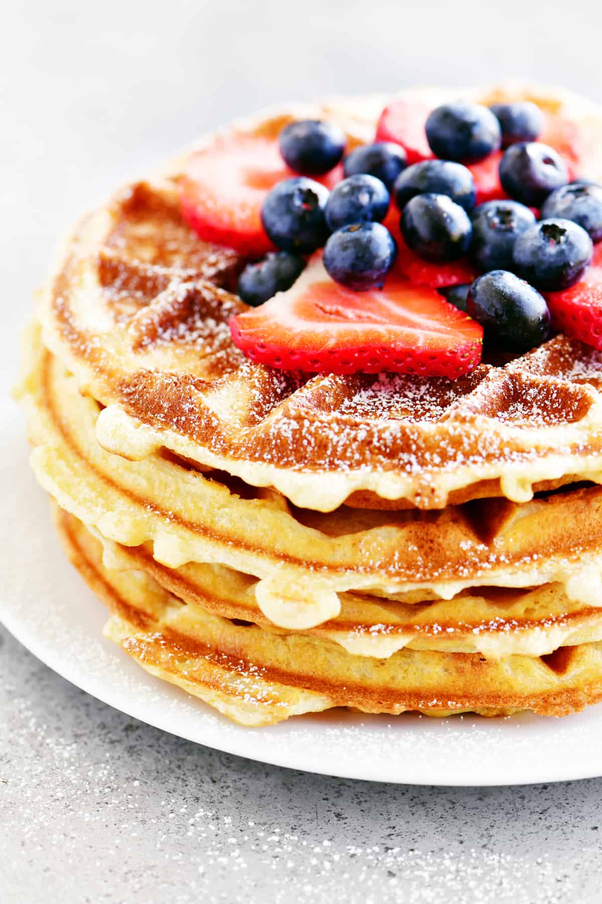 side view of stack of waffles with fruit on top