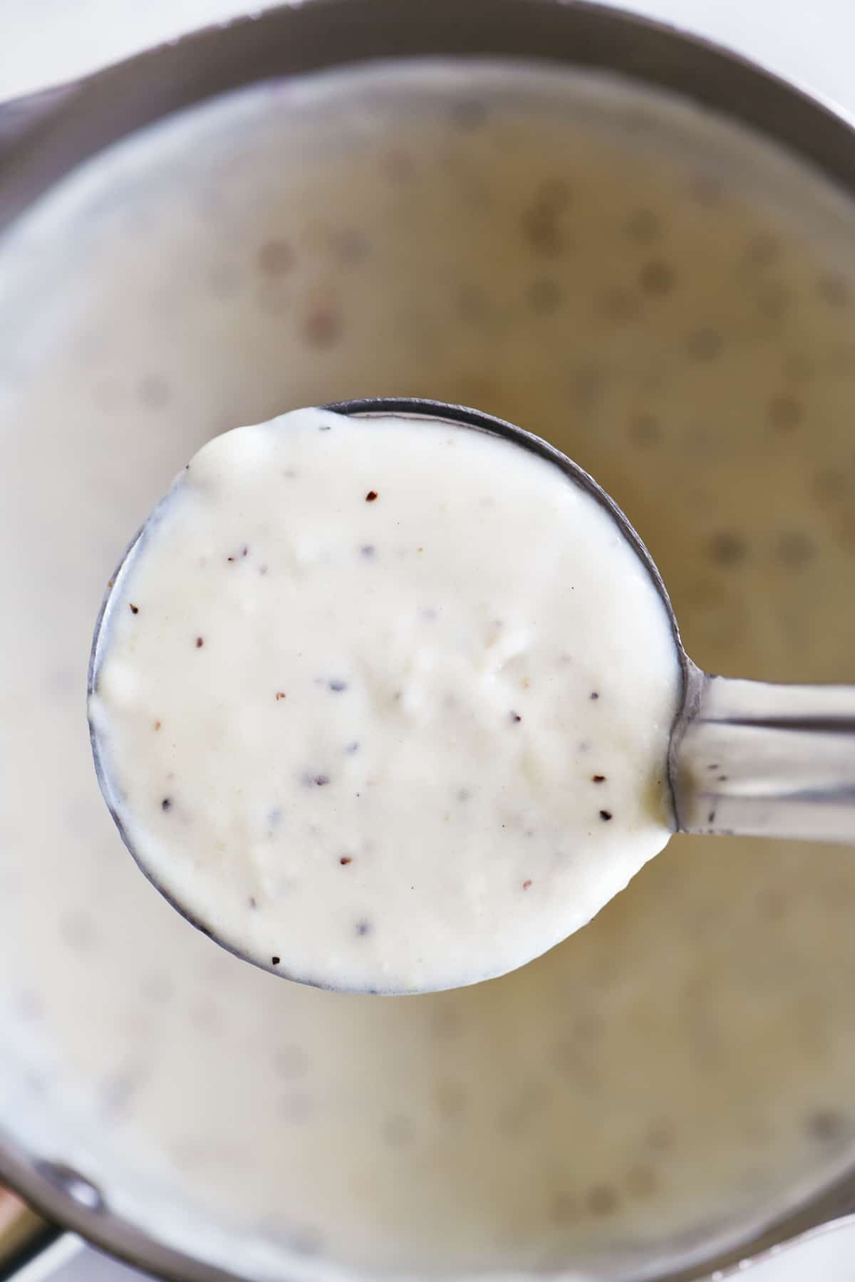 white peppered gravy in a ladle