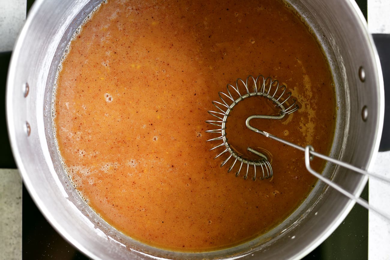whisking peach sauce in pot