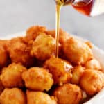 pouring maple syrup on corn fritters