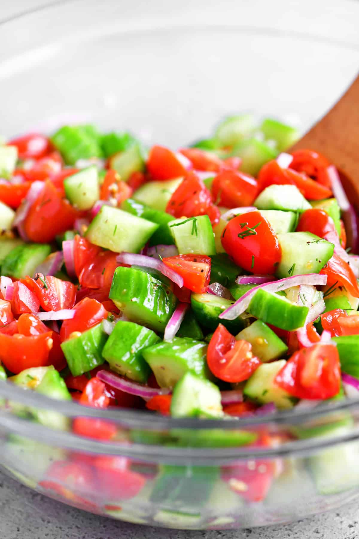 glass bowl containing tomato cucumber salad.